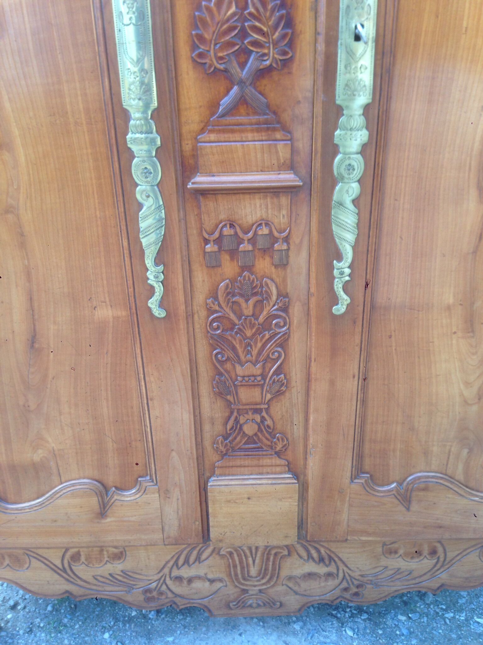 Armoire Louis XV Nantaise sculptée à grappes de raisin, chapeau de gendarme en cerisier fin 19eme.