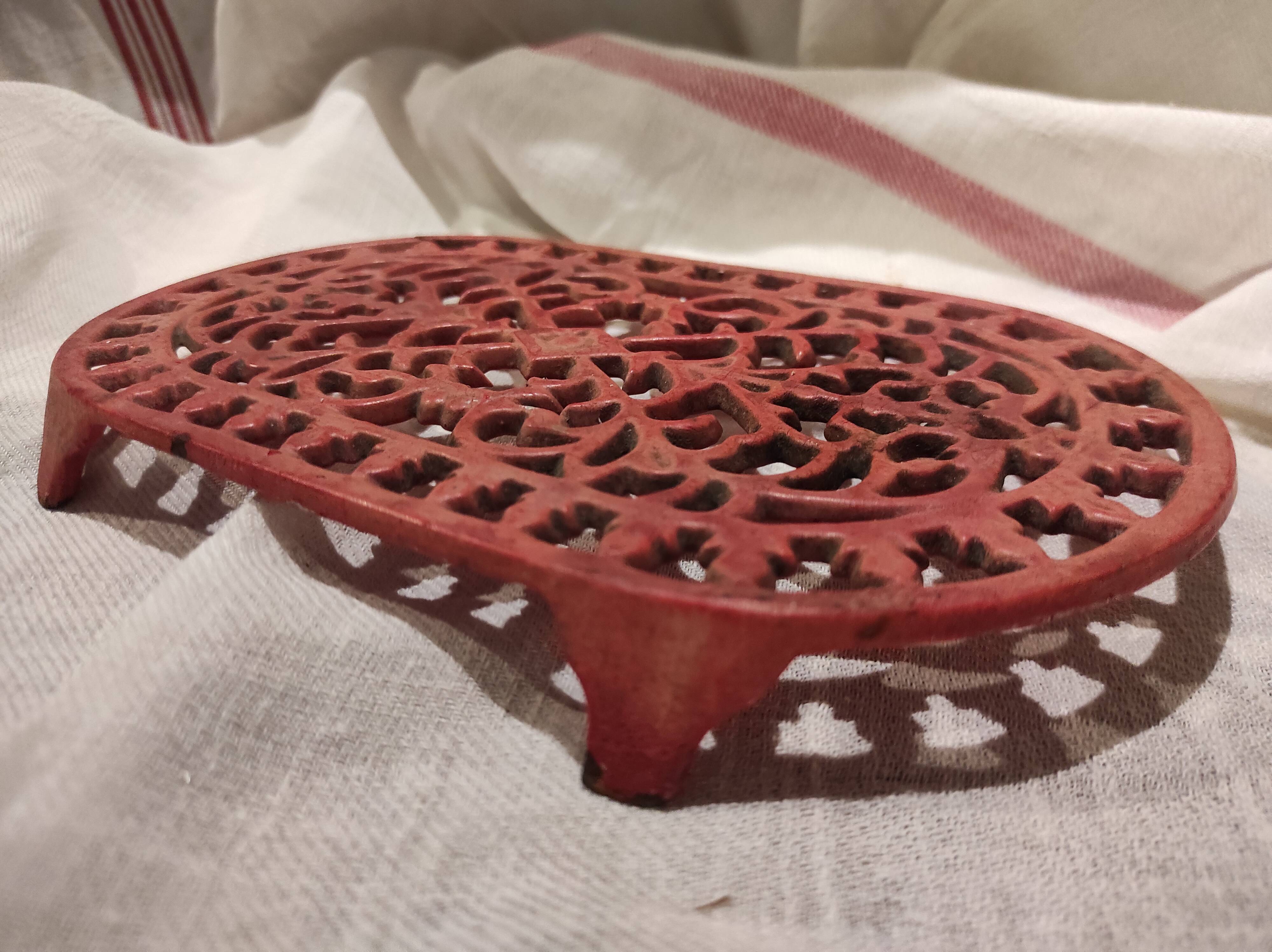 Vintage oval dark coral pink cast iron trivet