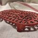 Vintage oval dark coral pink cast iron trivet