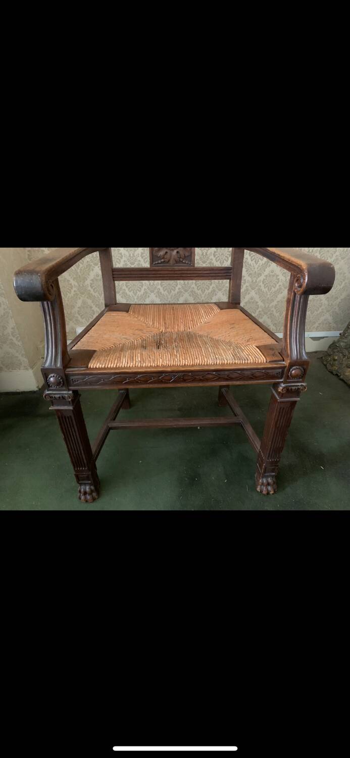 Antique armchair in carved wood with a straw seat.