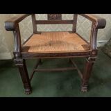 Antique armchair in carved wood with a straw seat.