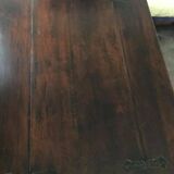 19th-century brown walnut dining table with sculpted trestle legs.