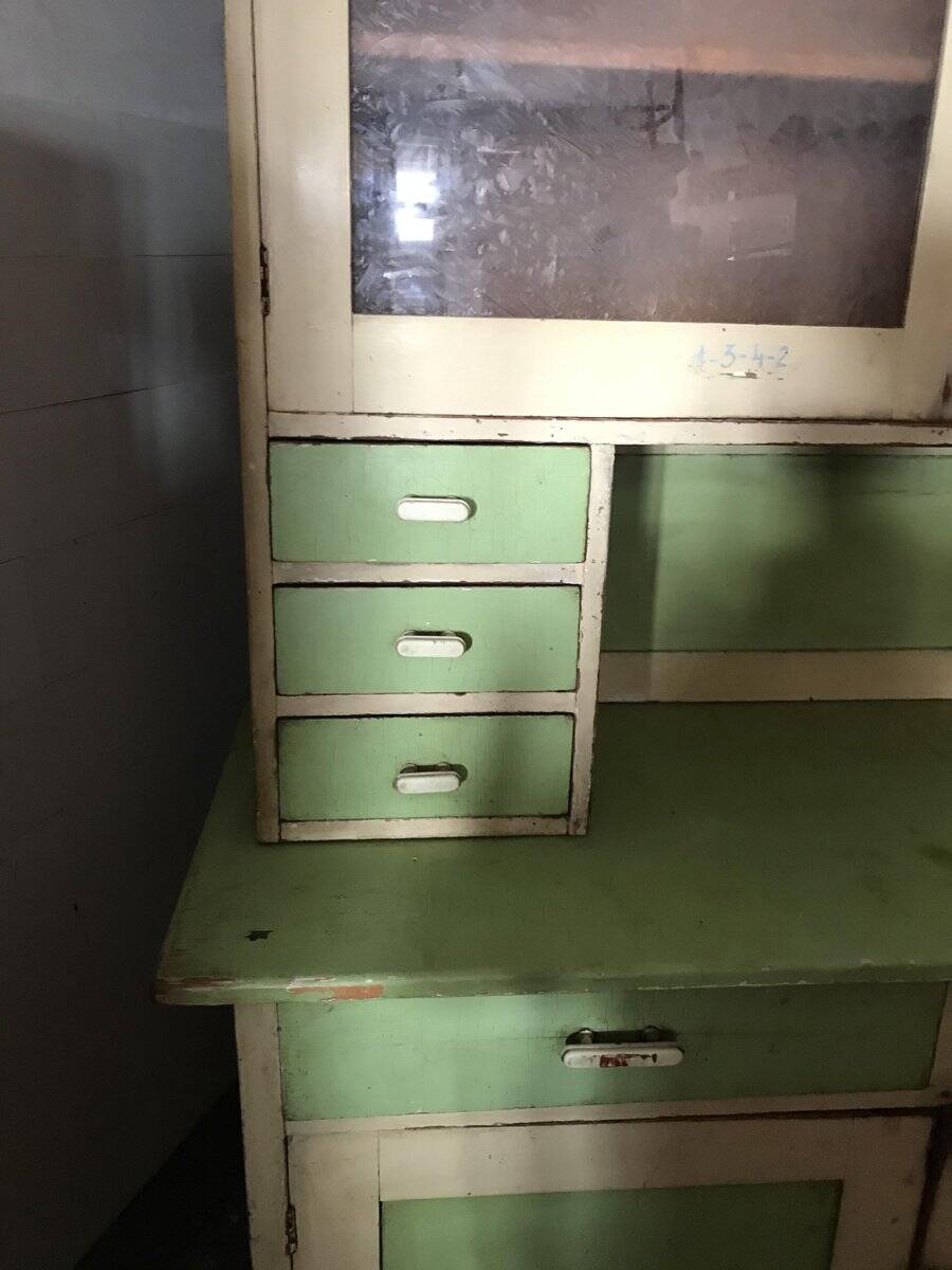 Vintage wooden kitchen cupboard painted green and beige, with glass doors - 1930s