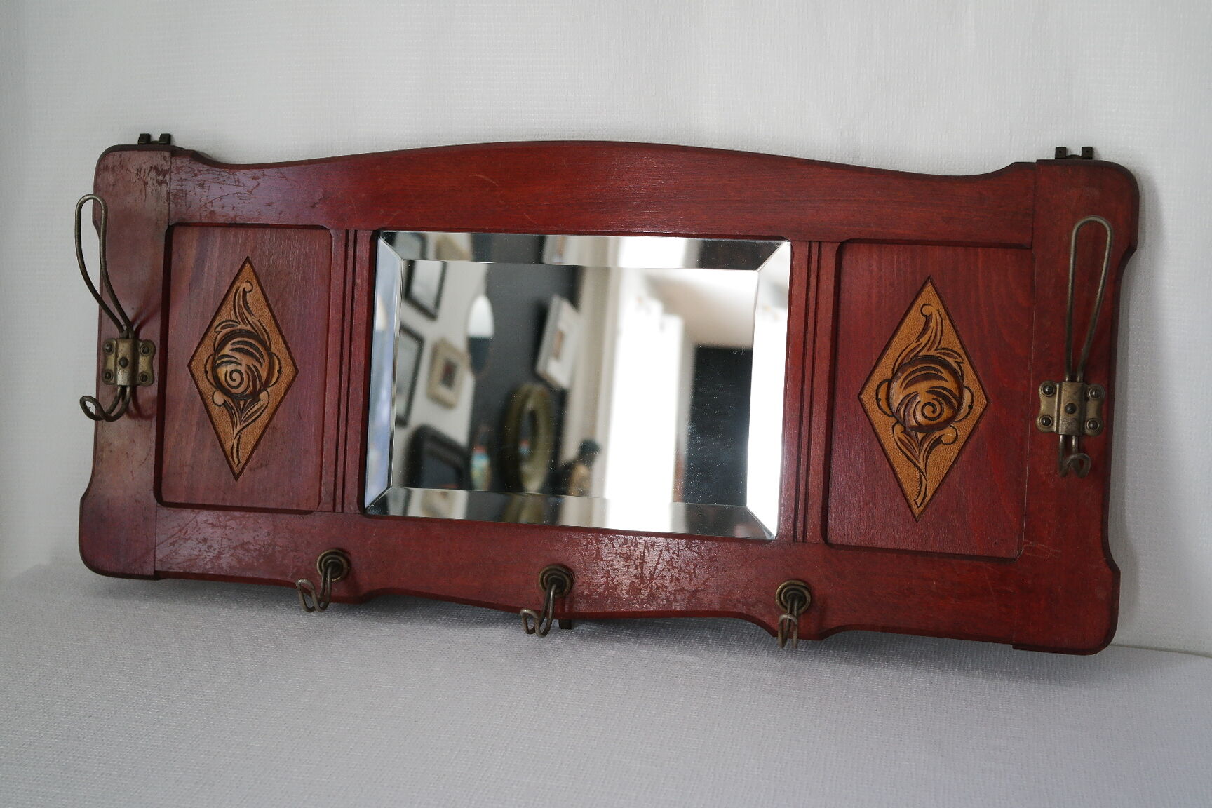 Red wooden wall-mounted coat rack and Art Deco mirror