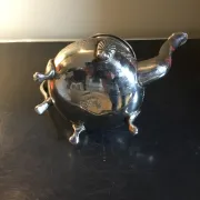 Traditional metal teapot with silver plating, Eastern style, on a stand.