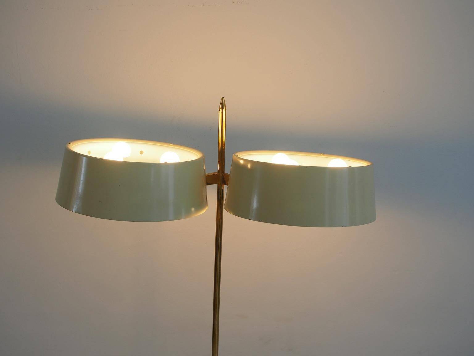 Brass and lacquered metal floor lamp with a wooden magazine shelf.