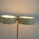 Brass and lacquered metal floor lamp with a wooden magazine shelf.