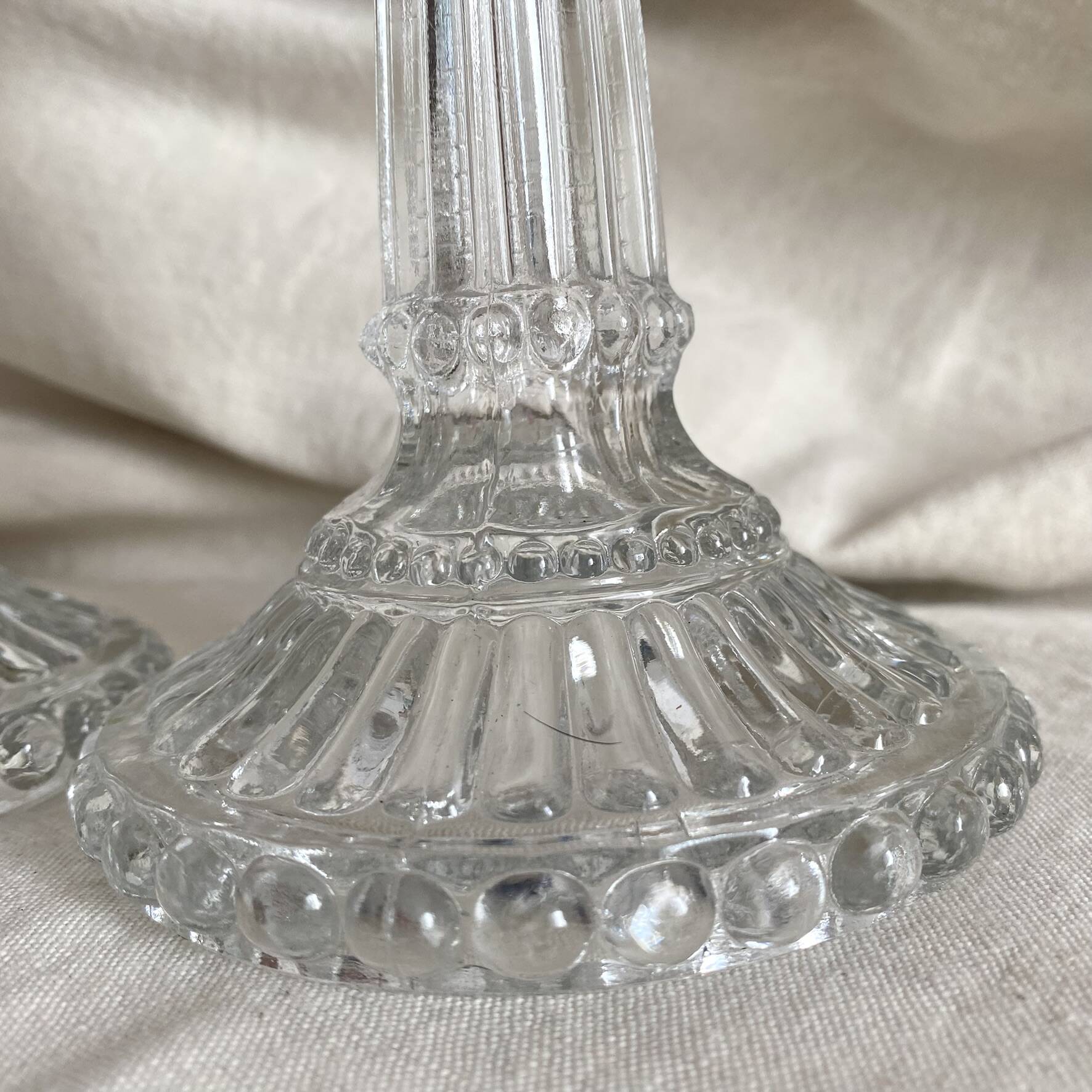 Column candle holders in moulded glass made in France.