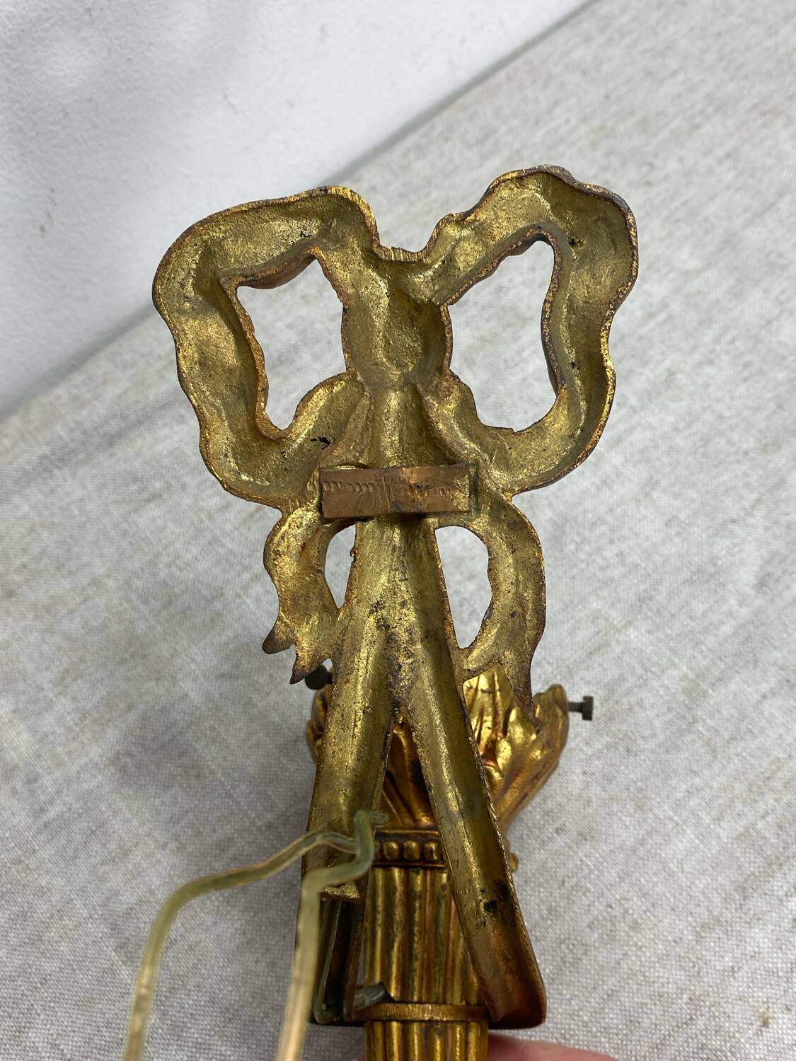 Bronze wall light, decorated with a bow and ribbon.