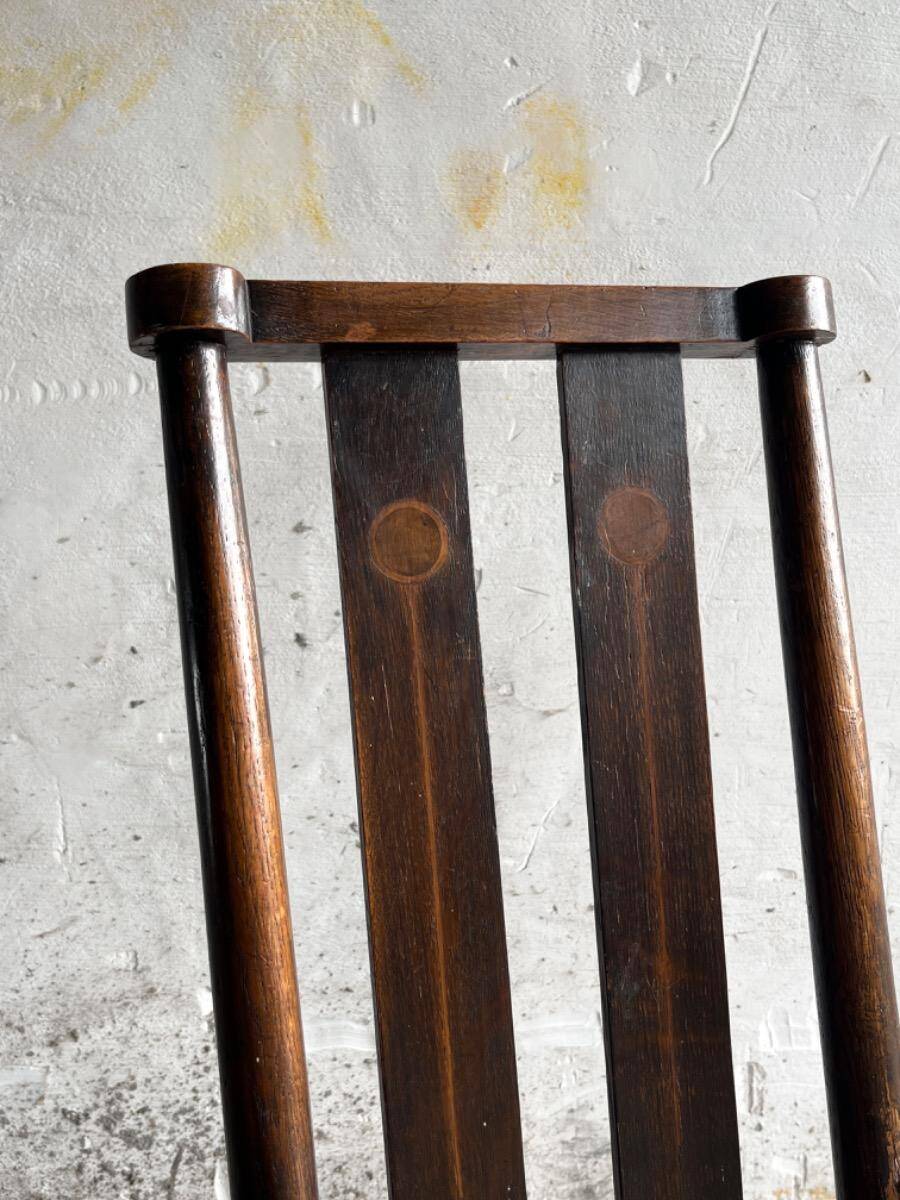 Dark brown solid wood Arts & Crafts armchair with natural rush seat and high back