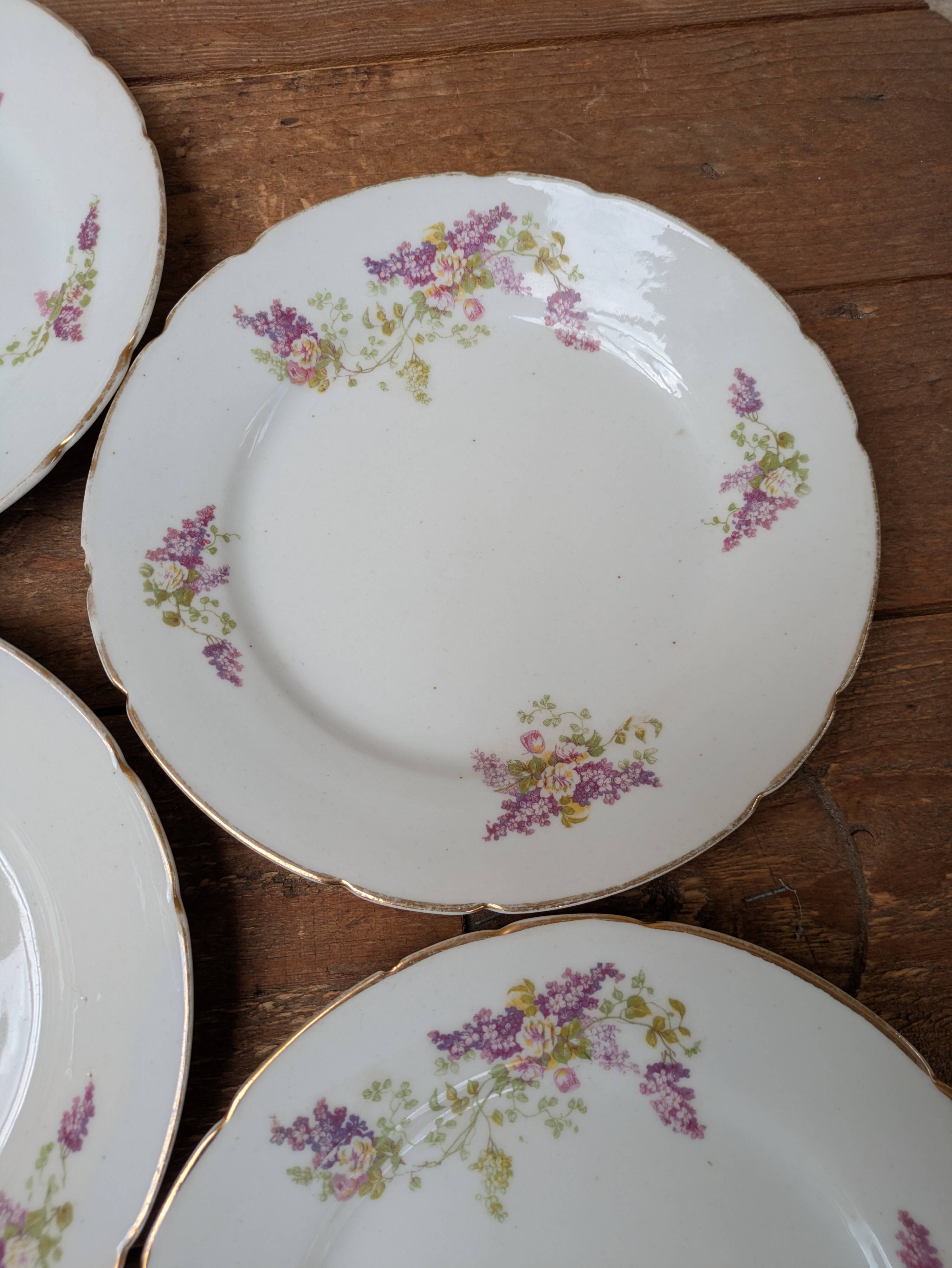 7 dessert plates in porcelain with a violet lilac design and a gold rim.