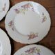 7 dessert plates in porcelain with a violet lilac design and a gold rim.