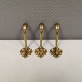 Three old and beautiful brass hooks with decorative motifs