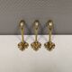 Three old and beautiful brass hooks with decorative motifs