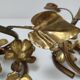 Pair of brass candle holders decorated with patinated metal flowers