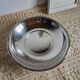Shallow round metal plate with pearl bead decoration.