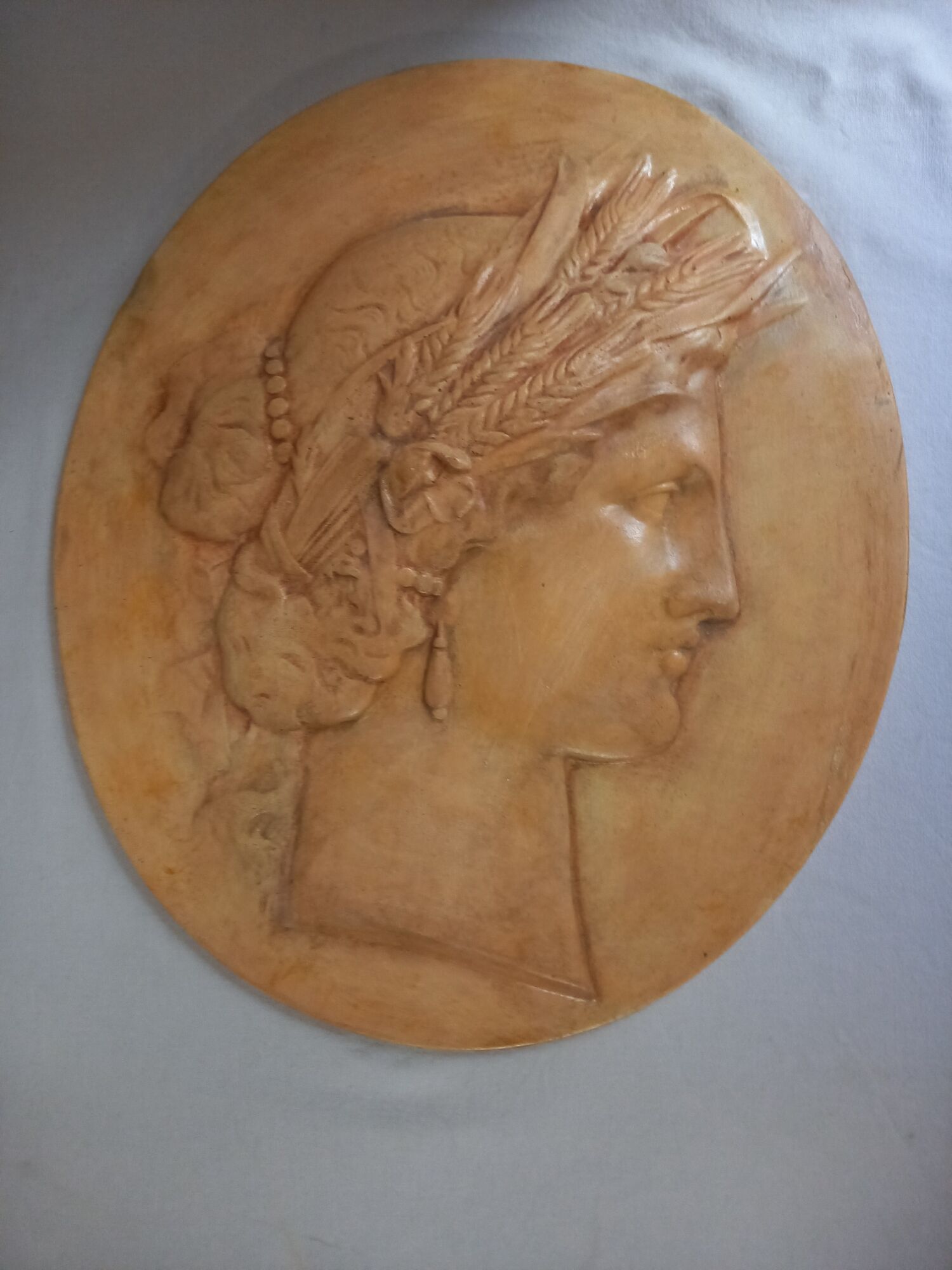 Plaster medallion, high relief, yellow ochre patina, representing the Roman divinity Ceres
