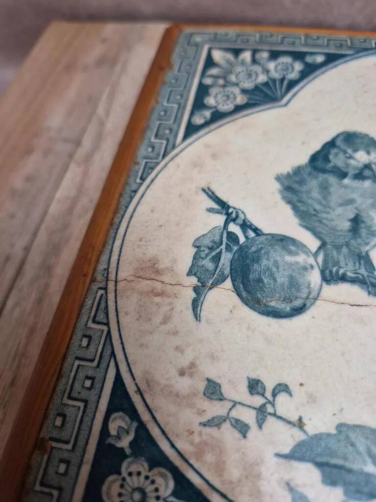 Antique trivet in Gien tile with blue bird decoration – wooden border