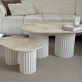 Oval coffee table duo travertine and white fluted wooden legs.