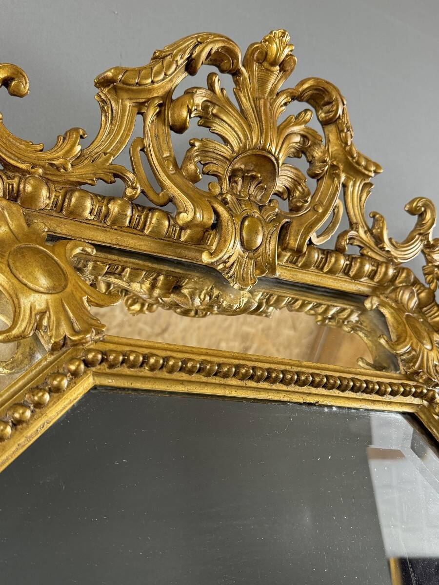 Antique octagonal mirror in richly carved gilded wood, Louis XV style.
