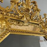 Antique octagonal mirror in richly carved gilded wood, Louis XV style.