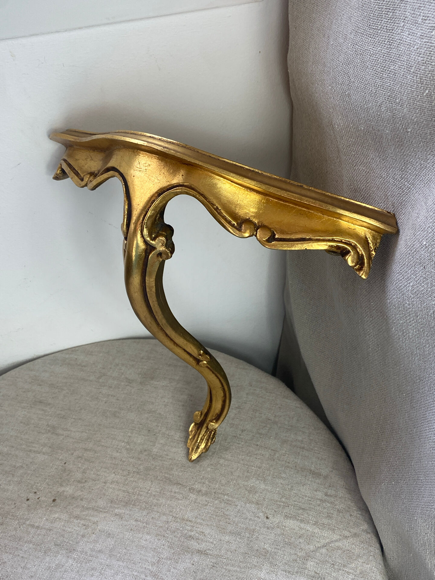 Small corner console in resin with a gold finish.