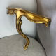 Small corner console in resin with a gold finish.