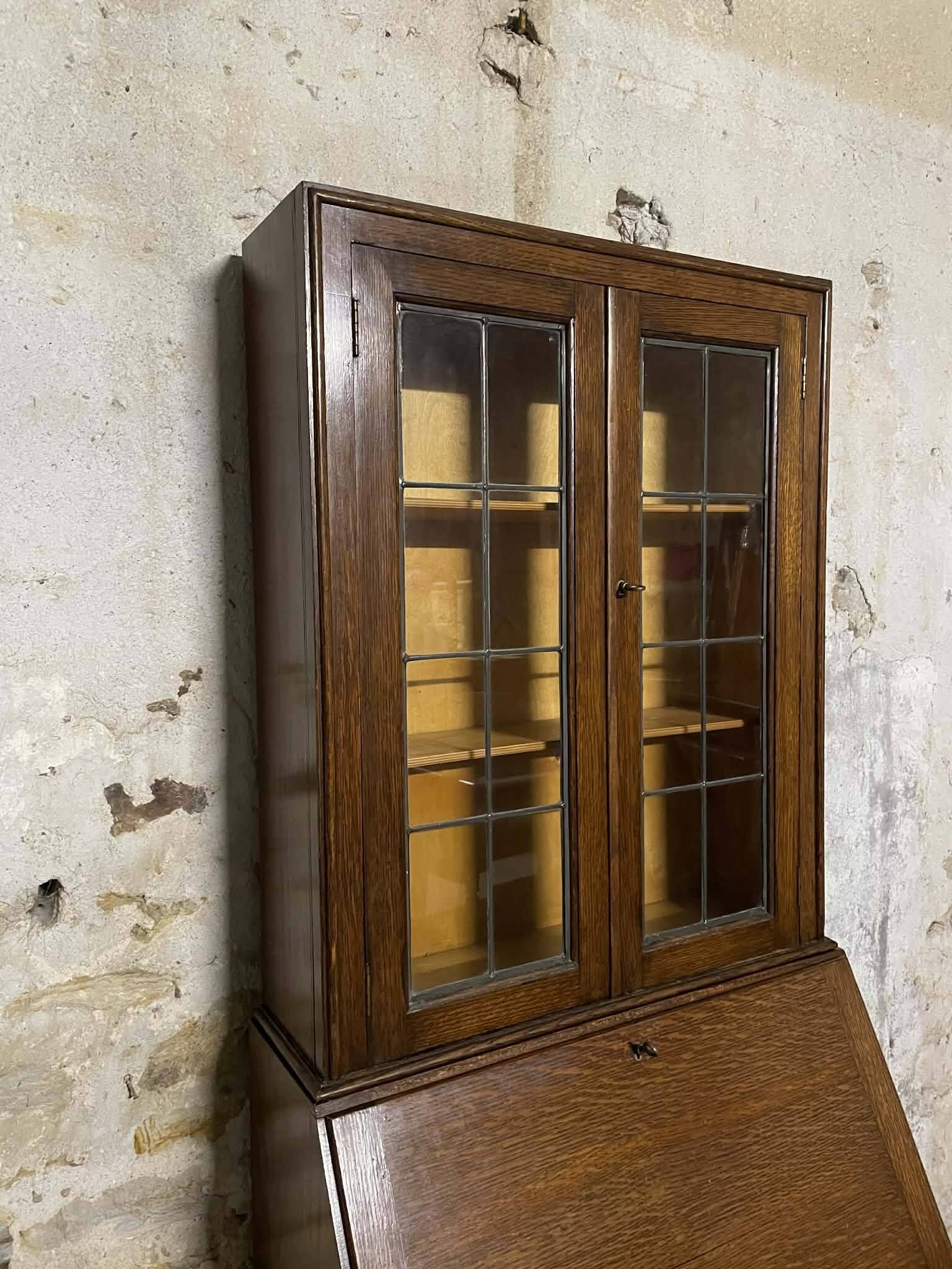 Oak display secretary cabinet with drop-down front, two sections.