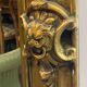 French palace mirror with bow and lion heads, gilded frame.