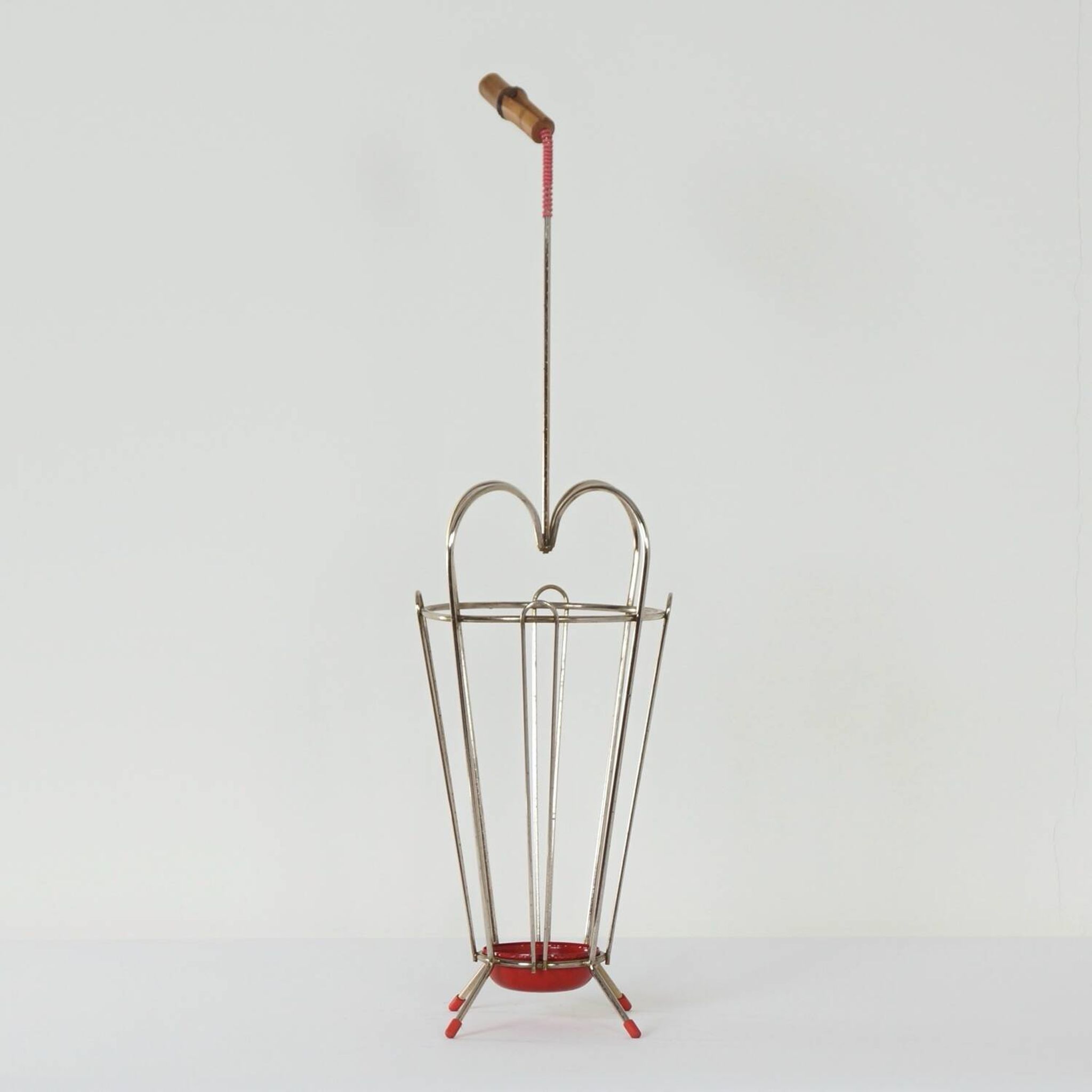 VINTAGE UMBRELLA STAND OF CURVED METAL, RED DETAILS AND A BAMBOO HANDLE, 1950S