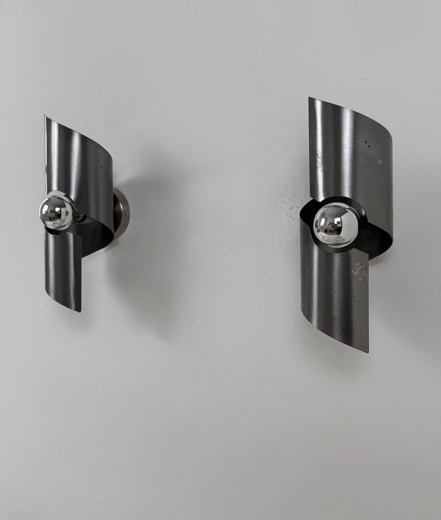 Pair of vintage wall lights, curved patinated steel, France, 1970.