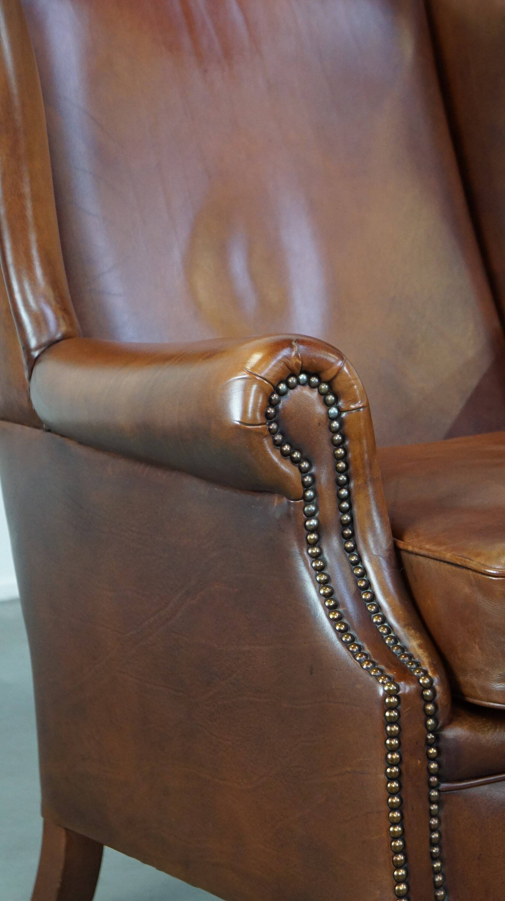 Fauteuil à oreilles en cuir de vachette cognac