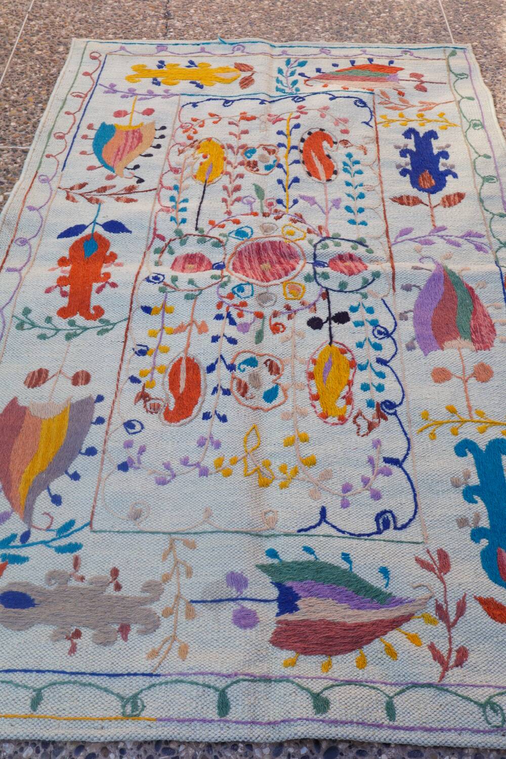 White suzani kilim rug with embroidered colorful patterns