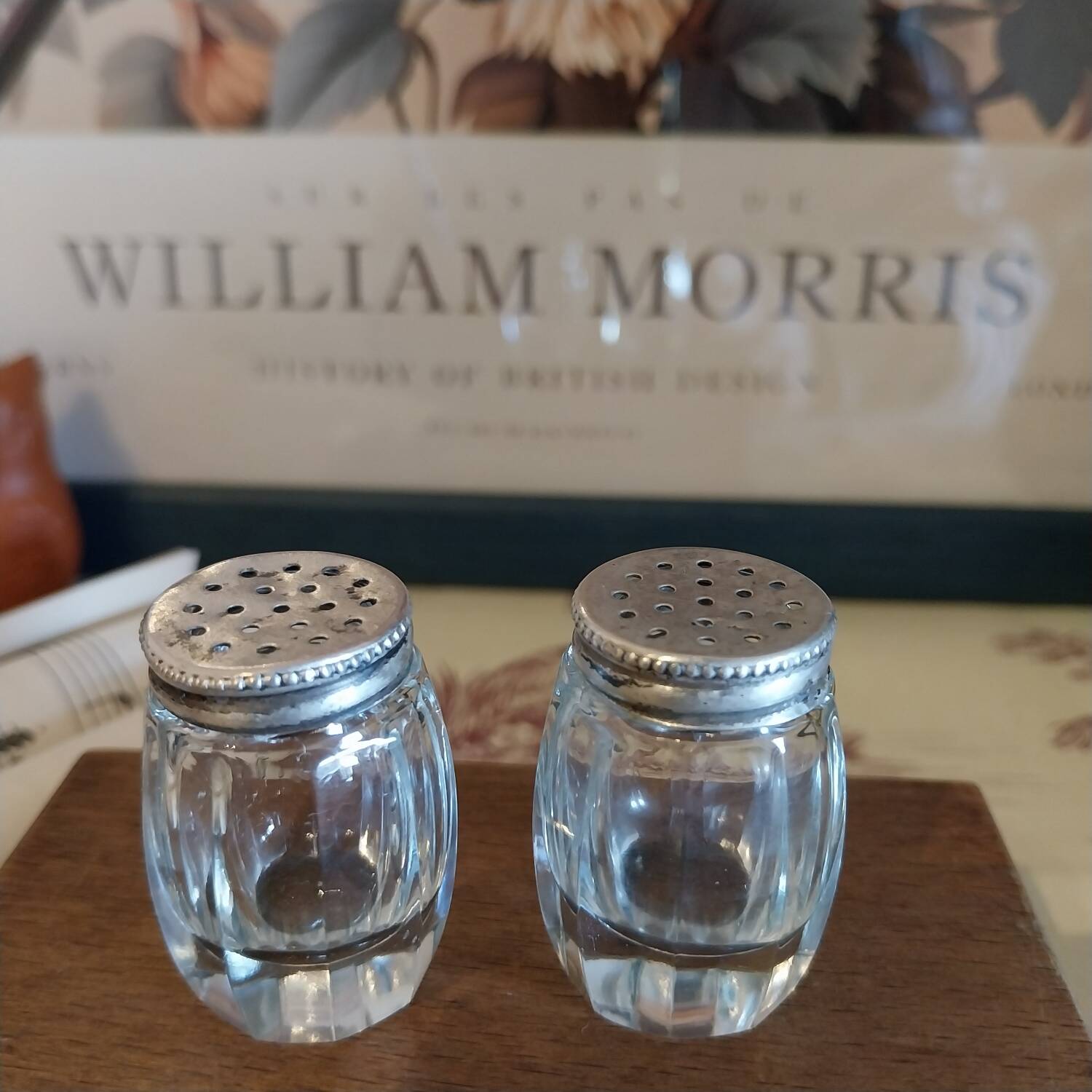 Antique salt and pepper shakers in crystal and silver metal.
