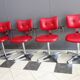 Quatre chaises de barbier en cuir rouge des années 1960 avec accoudoirs bakelite