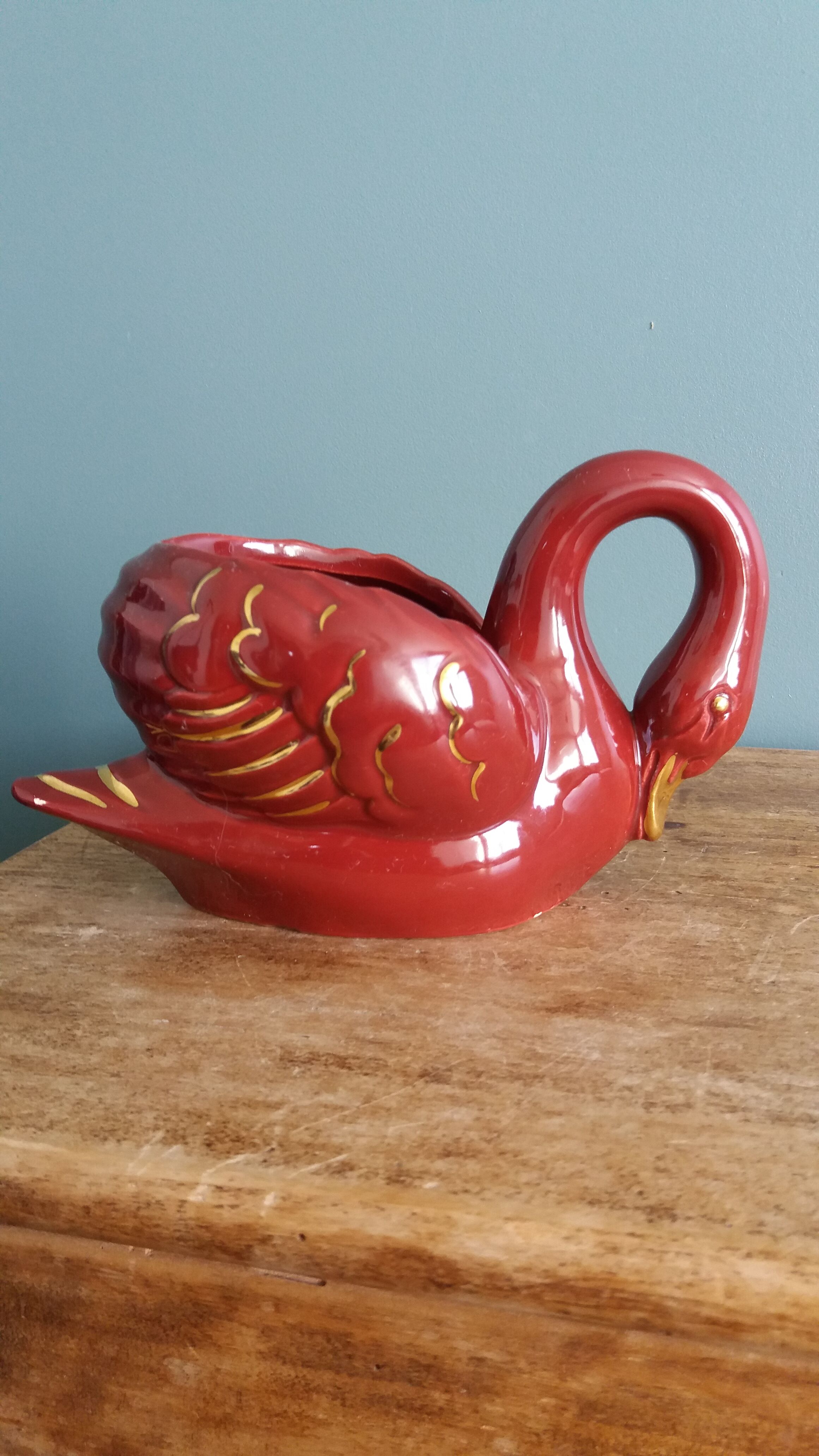Poet Laval swan hides zoomorphic pot in burgundy ceramic.