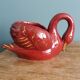 Poet Laval swan hides zoomorphic pot in burgundy ceramic.