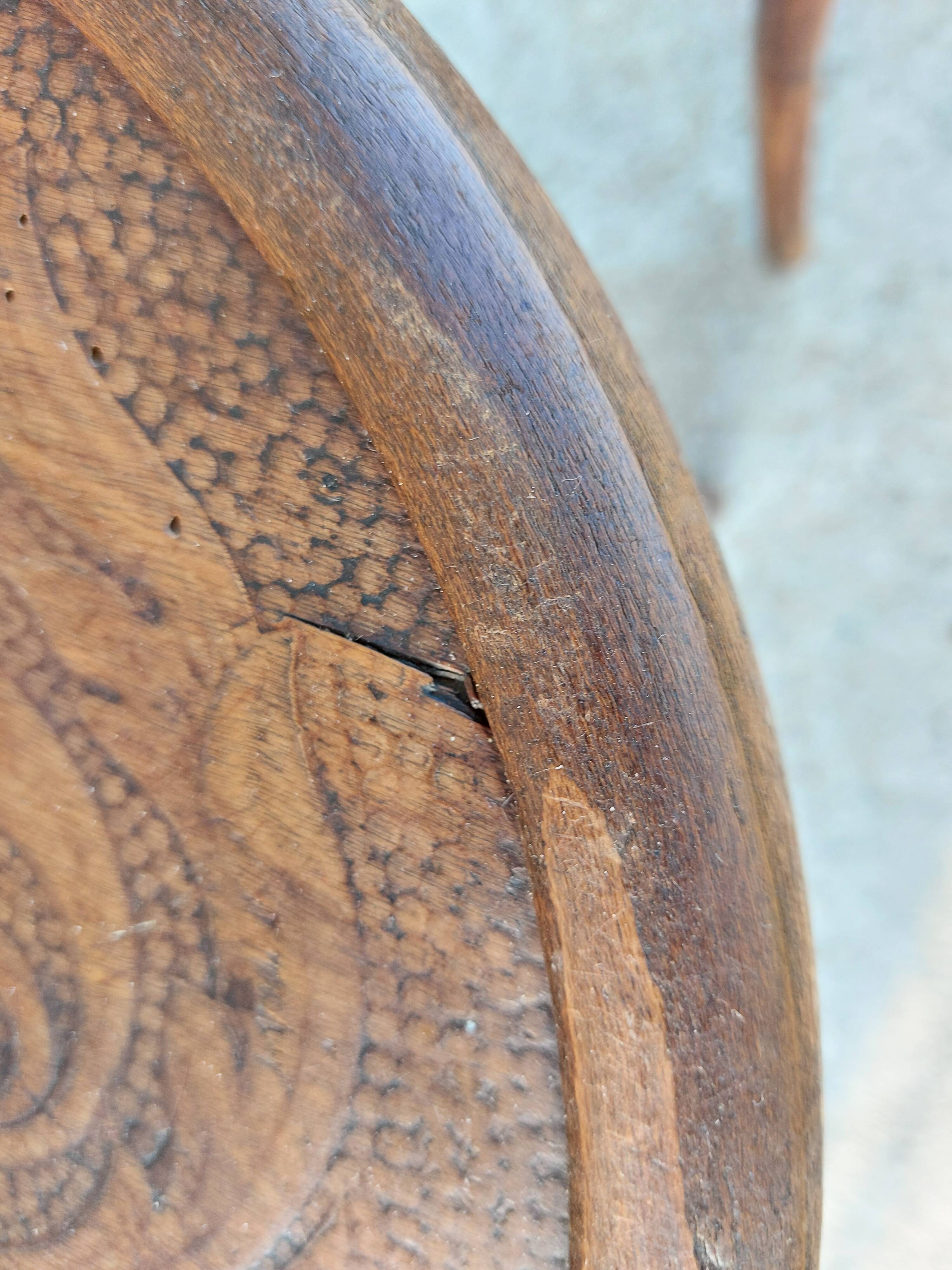 pair of round wooden chairs with a pattern on the seat