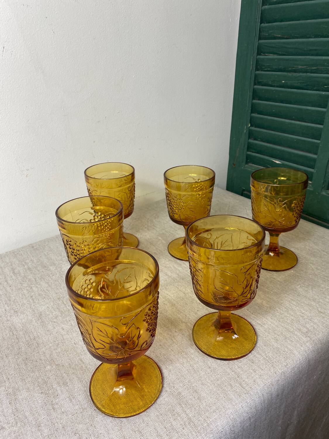 Six amber-colored stemmed glasses