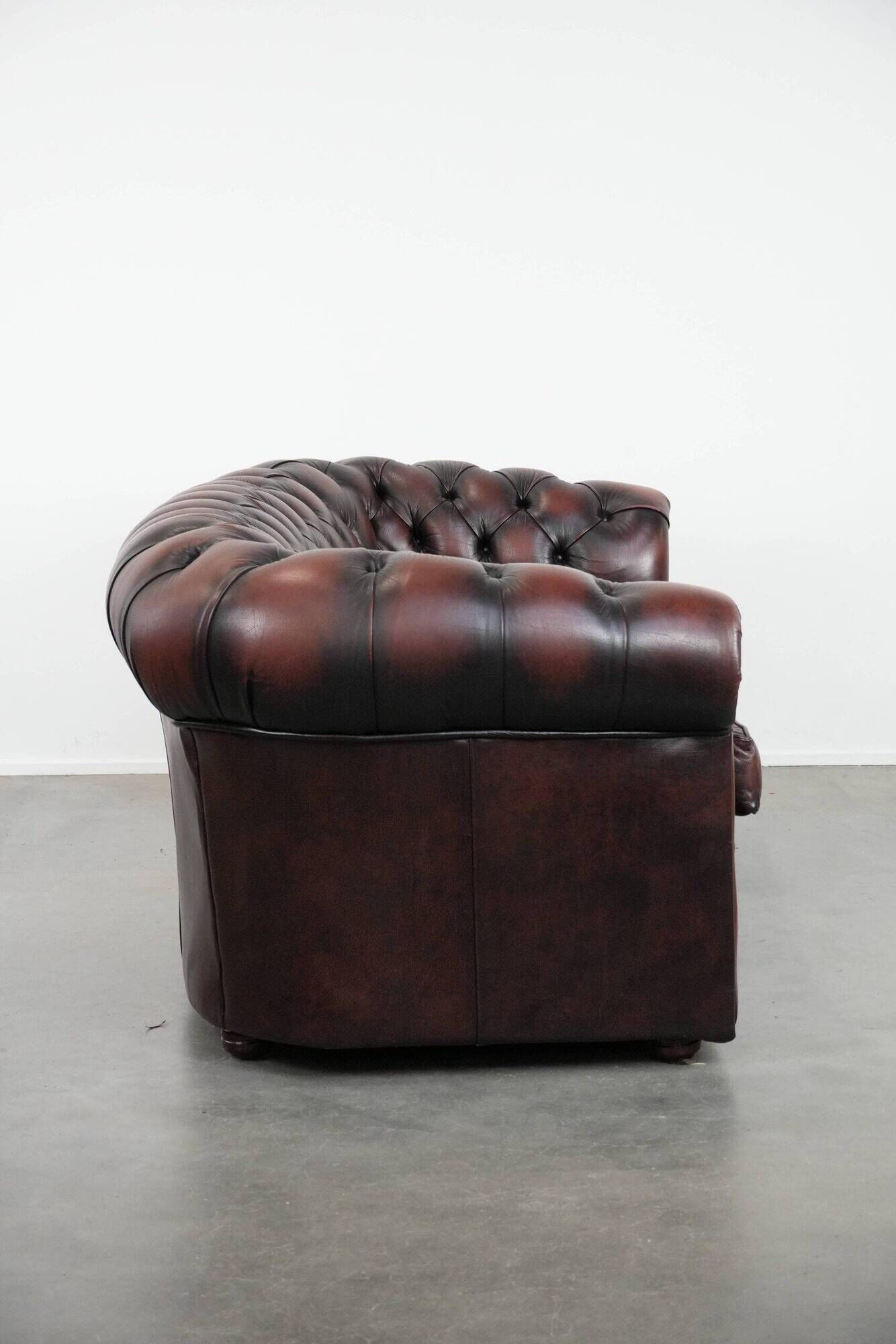 Classic cowhide Chesterfield sofa in English style with red/brown colours