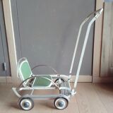 Old foldable stroller on metal wheels. Toy from the 50s
