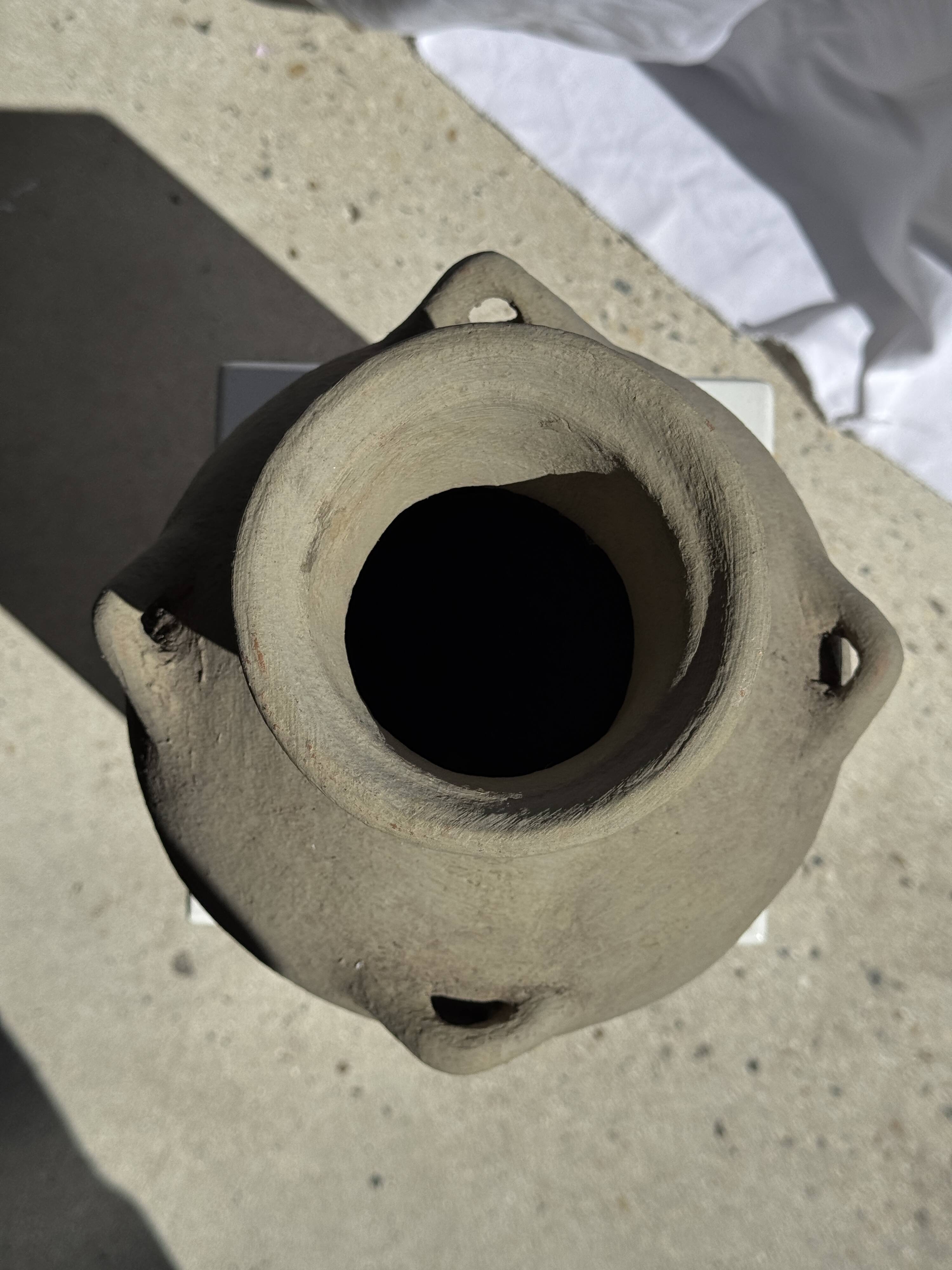 Light beige-grey Indonesian terracotta vase with 4 small handles and a high neck.
