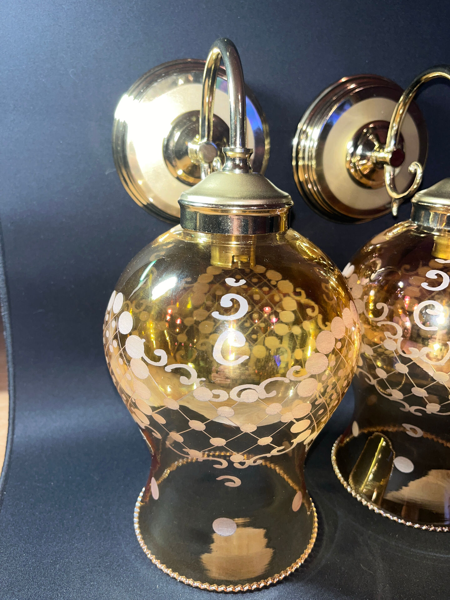 Pair of vintage wall sconces in brass with amber glass globes.