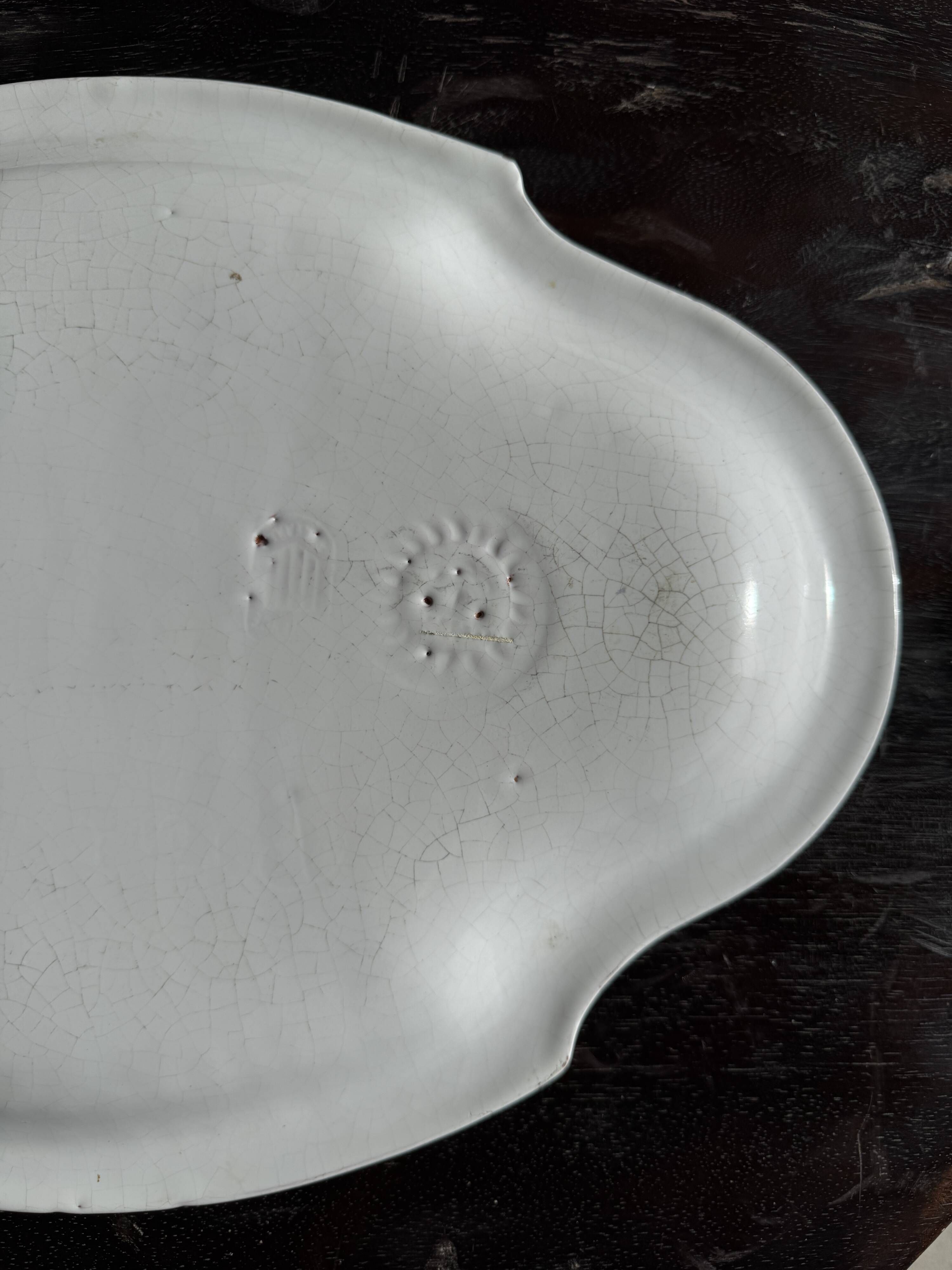 Antique oval-shaped white crackled faience plate with a scalloped edge.