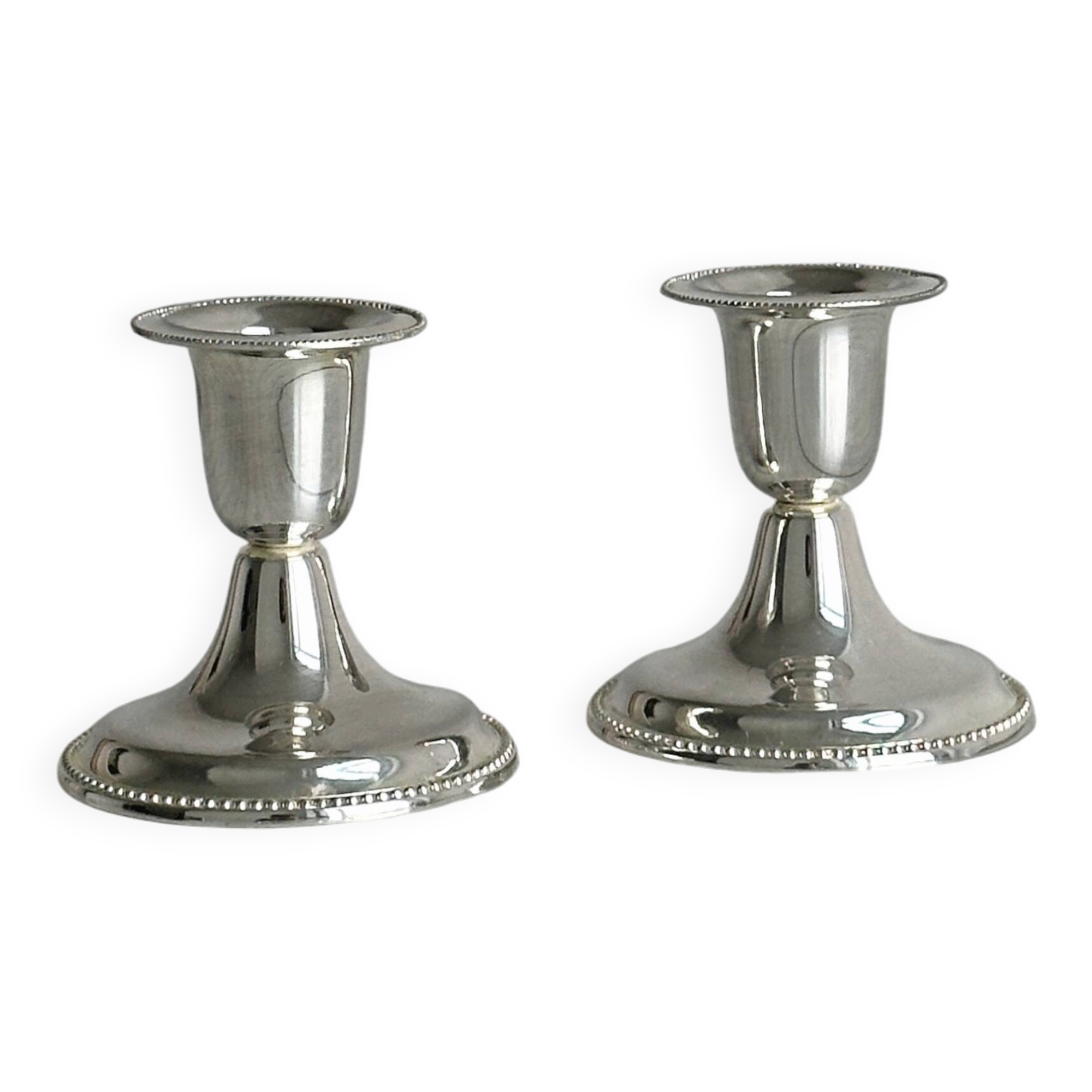 A pair of small silver-white metal candle holders.
