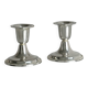 A pair of small silver-white metal candle holders.