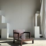 Small low armchair in varnished brown wood