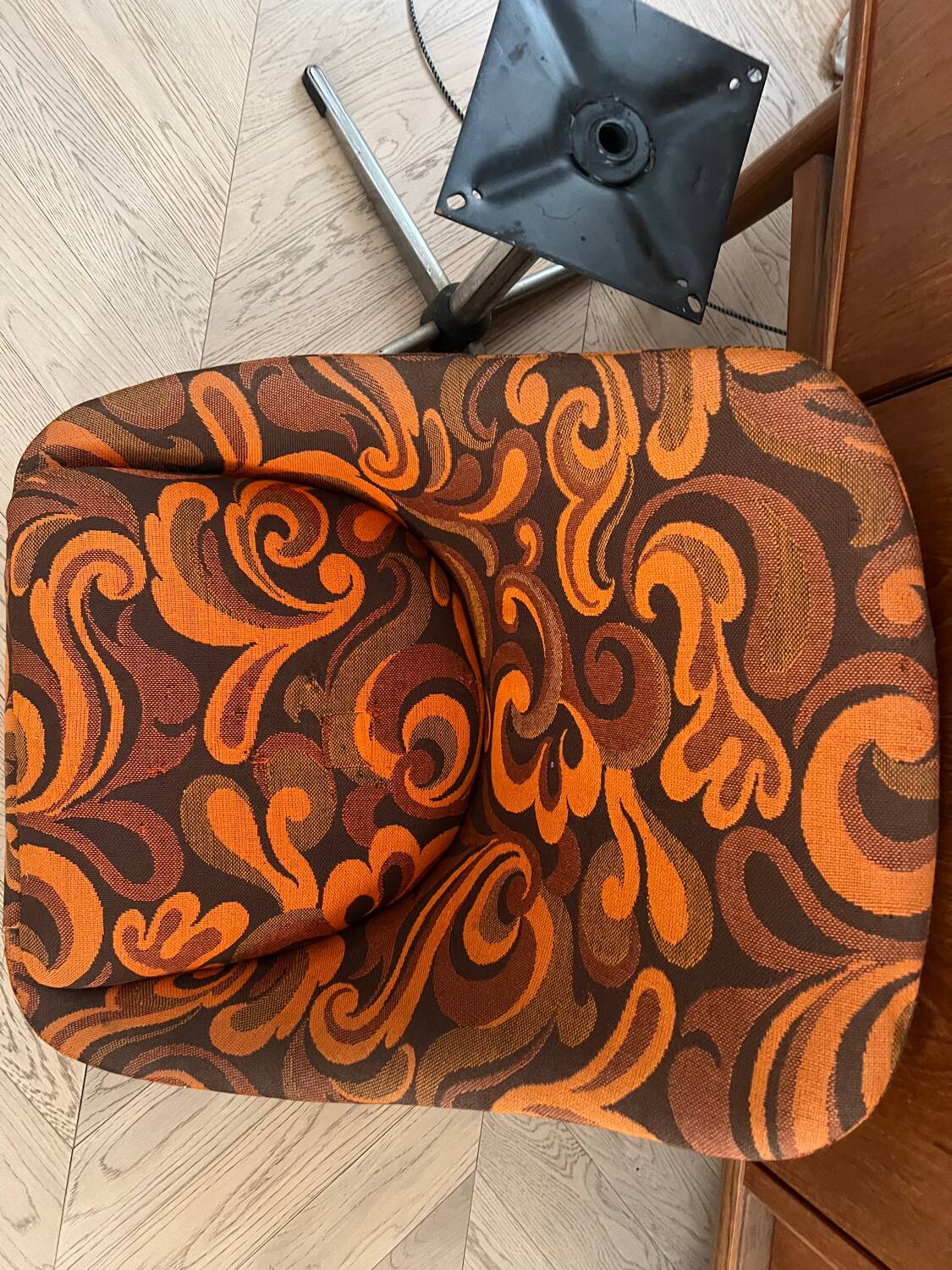 Vintage space age swivel chair with psychedelic pattern in shades of orange.