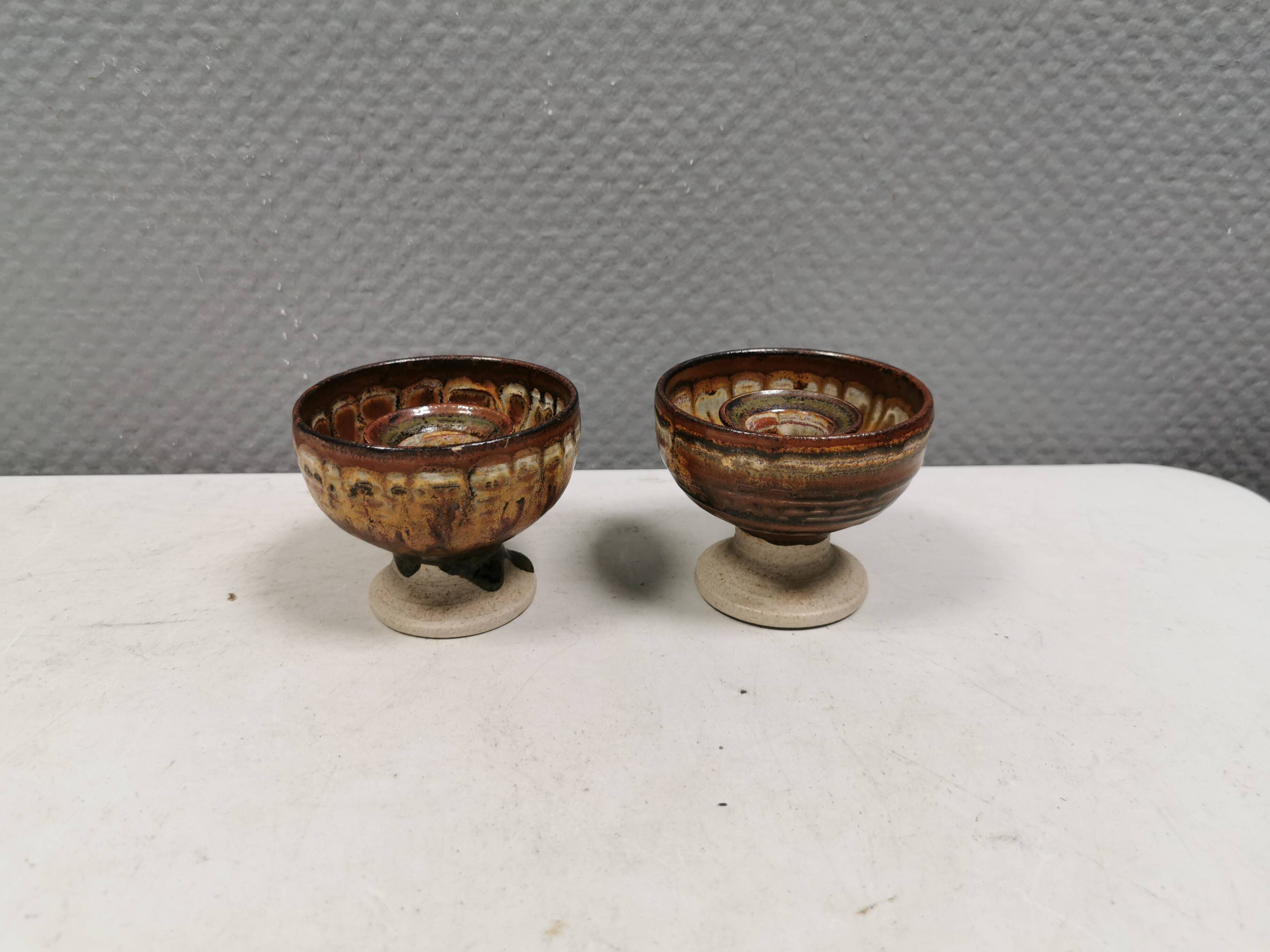 A set of ceramic candle holders in earthy colours.