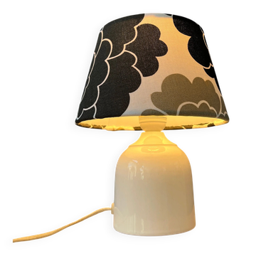 Small Space Age table lamp with a porcelain base and black and white flower shade.